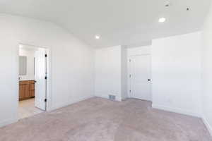 Master bedroom with light colored carpet, lofted ceiling, baseboards, recessed lighting, and a smoke detector