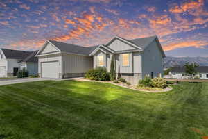 View of front of home featuring board and batten siding, a garage, driveway, and a lawn