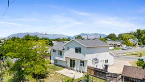 Back of property with a patio, a shingled roof, and a mountain view