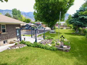 View of grassy yard with a mountain view, a gazebo, and a patio