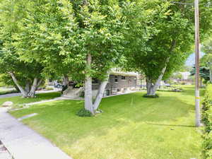 View of grassy yard featuring stairs