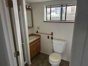 Bathroom featuring vanity, toilet, and baseboards