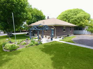 Back of property with a chimney, brick siding, and a patio area