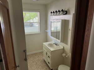 Bathroom featuring vanity, baseboards, and toilet
