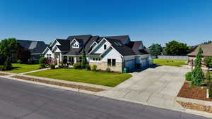 Craftsman-style house with stone siding, concrete driveway, 4 car garage