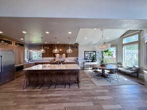 Kitchen featuring built in refrigerator, light countertops, a chandelier, bay window and dinning room