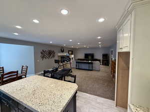 Basement Kitchen with recessed lighting, a kitchen island, white cabinets, Granite stone counters