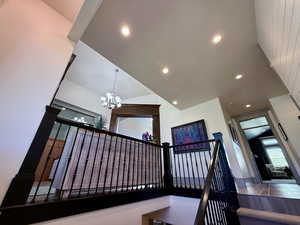 Staircase with a chandelier, recessed lighting, and high vaulted ceiling