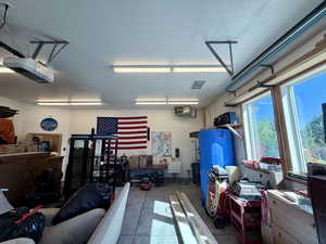 Garage with a garage door opener and a sink and heater