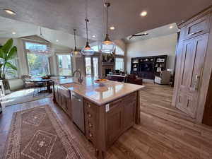 Kitchen featuring vaulted ceiling, farm house sink, Walnut cabinets and Hidden pantry door