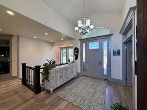 Entrance foyer featuring high vaulted ceiling, tile wood floors