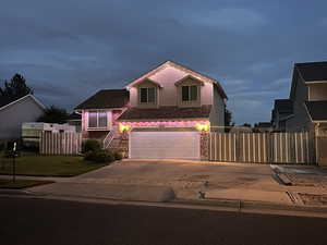 View of front of house with driveway, an attached garage, and stone siding