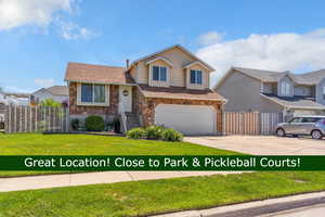 Tri-level home featuring stone siding, driveway, and an attached garage