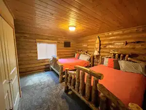 Bedroom featuring wood ceiling, log walls, and carpet flooring