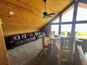 Living room with carpet, wooden ceiling, healthy amount of natural light, vaulted ceiling, and ceiling fan