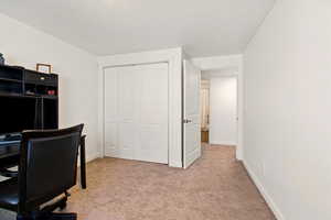 Home office featuring light carpet and baseboards