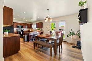 Dining room with light wood finished floors, recessed lighting, and baseboards