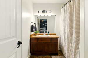 Full bath featuring vanity, a ceiling fan, baseboards, and curtained shower