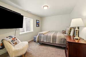 Bedroom with light colored carpet and baseboards