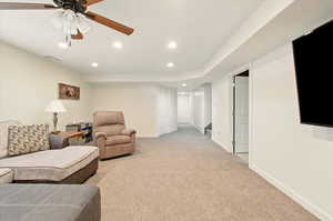 Living room with recessed lighting, light colored carpet, ceiling fan, and baseboards