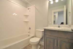 Bathroom featuring vanity,  shower combination, toilet, and wood finished floors