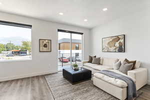Model Home Living room with wood finished floors, recessed lighting, and baseboards