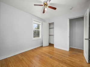Unfurnished bedroom featuring baseboards, a closet, and light wood-style flooring