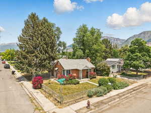 View of front of home with a mountain view, brick siding, and a chimney