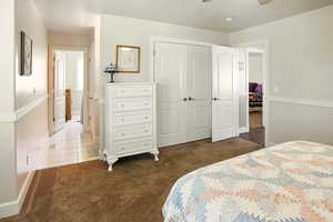 Carpeted bedroom with a closet, baseboards, and tile patterned floors