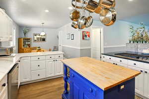 Kitchen with wooden counters, blue cabinetry, stainless steel appliances, light wood-style floors, and recessed lighting