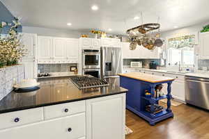 Kitchen with stainless steel appliances, a sink, tasteful backsplash, and recessed lighting