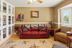 Living area with ceiling fan and wood finished floors