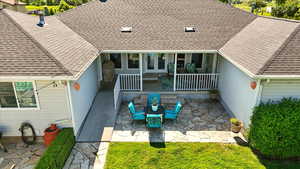 Back of property with a patio area and a shingled roof