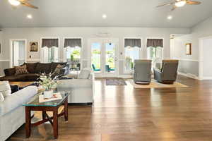 Living room featuring a ceiling fan, wood finished floors, recessed lighting, baseboards, and lofted ceiling