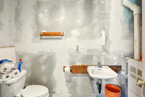Workshop half bathroom featuring toilet and a sink
