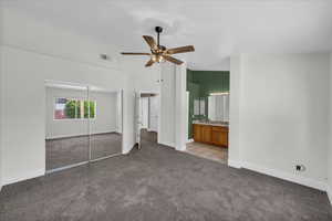 Unfurnished bedroom featuring carpet, baseboards, a closet, a high ceiling, and a ceiling fan
