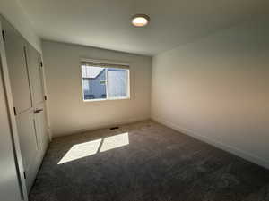 Unfurnished bedroom with carpet and baseboards