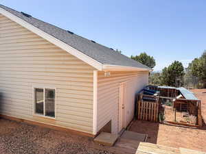 View of side of home featuring roof with shingles