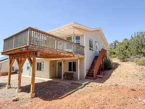 Back of house featuring a deck, a patio area, and stairway
