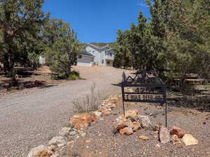 View of front facade featuring dirt driveway and a garage