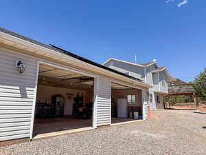 View of property exterior featuring a garage and gravel driveway