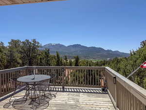 Wooden deck with a mountain view and outdoor dining space