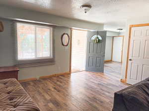 Entrance foyer featuring baseboards, wood finished floors, and a textured ceiling