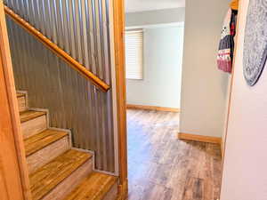 Staircase with wood finished floors and baseboards