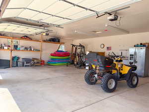 Garage with stainless steel refrigerator with ice dispenser and a garage door opener