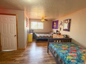 Bedroom featuring wood finished floors, a textured ceiling, and a ceiling fan