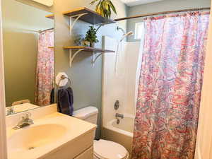 Bathroom with toilet, shower / bath combo, and vanity