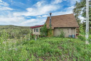 View of side of property with roof with shingles