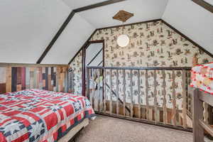 Carpeted bedroom with vaulted ceiling, wallpapered walls, a textured ceiling, and multiple windows