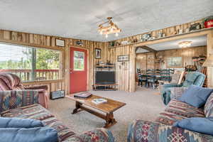 Living area featuring wood walls and carpet floors